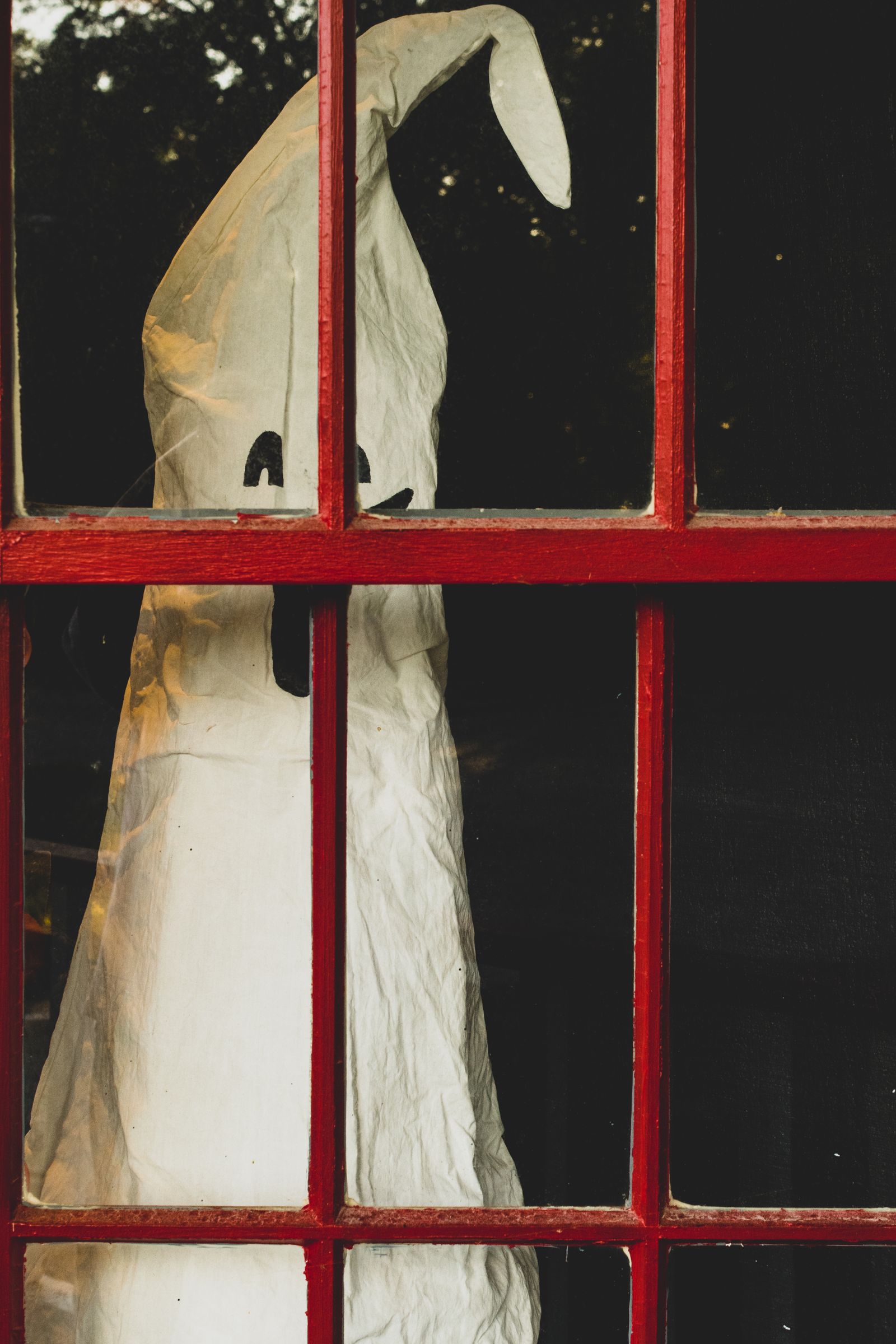 A ghost decoration behind a red window frame