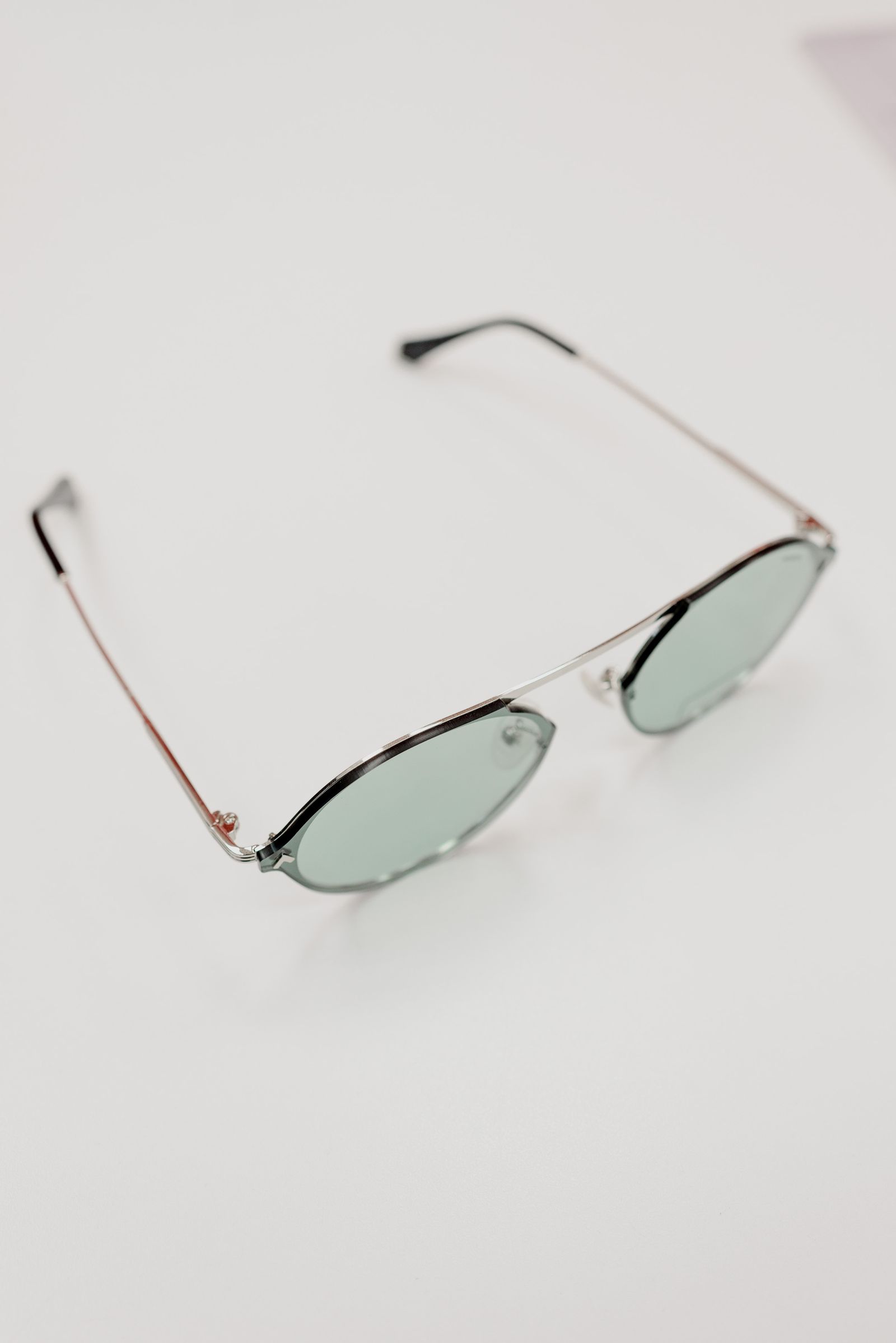 Pale-framed eyeglasses resting on a white surface