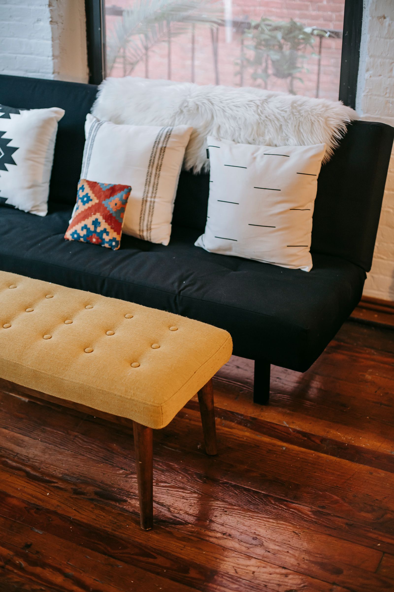 Assorted cushions arranged on a dark sofa