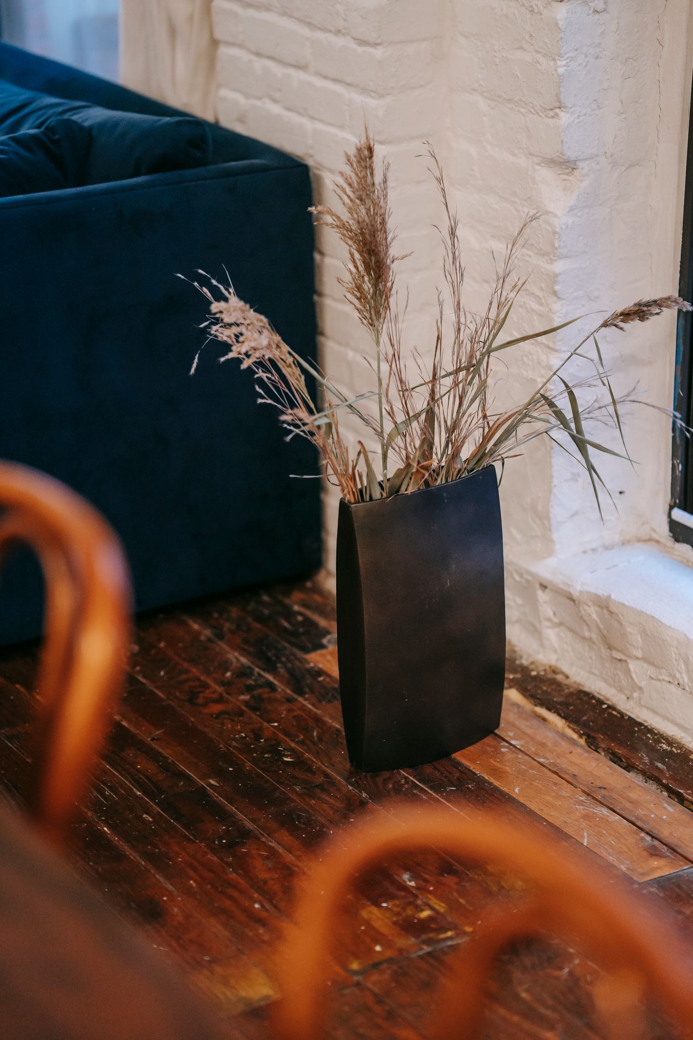 Tall rectangular floor vase beside a blue chair