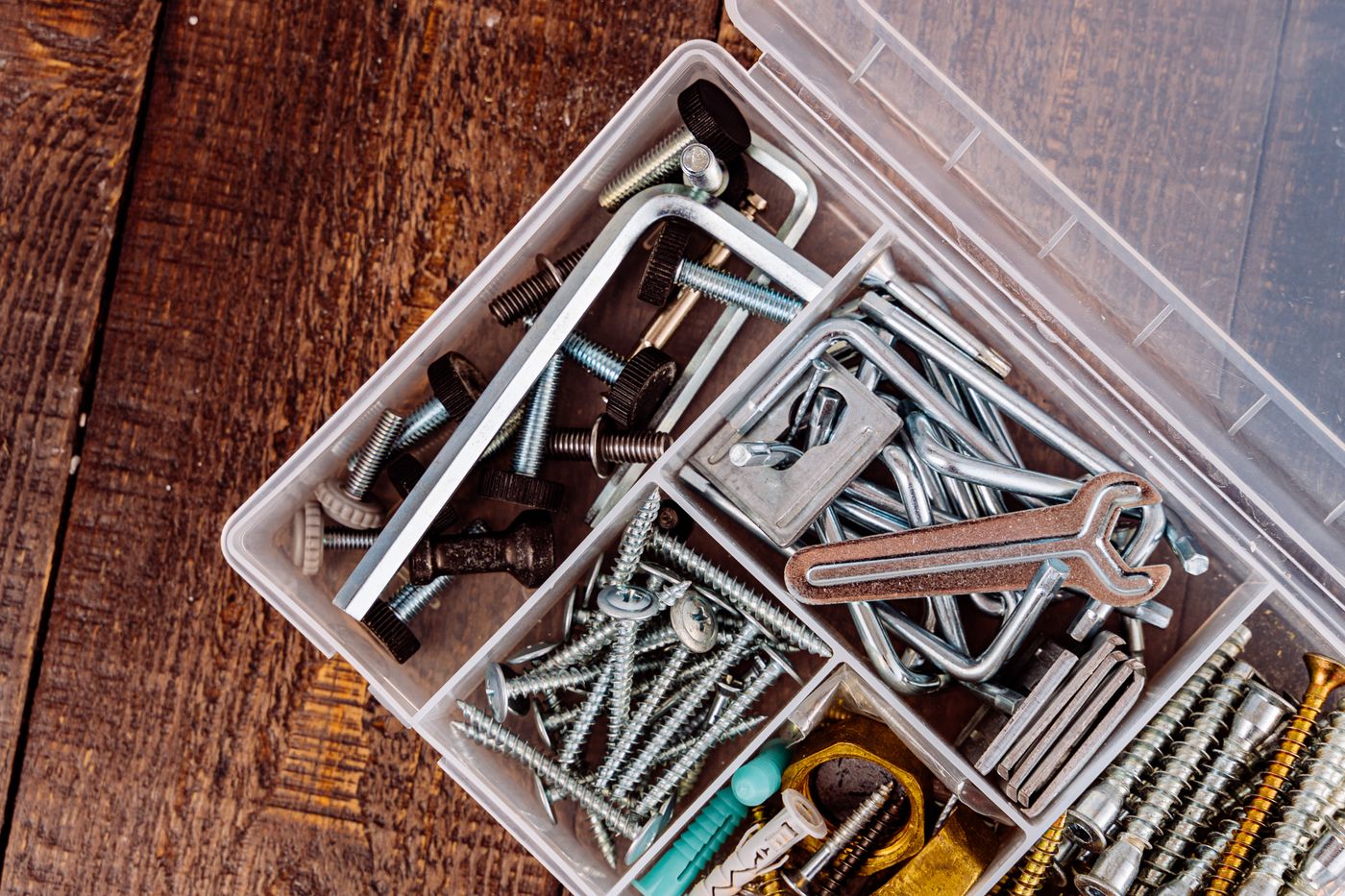Mixed small fasteners and tools in an open box