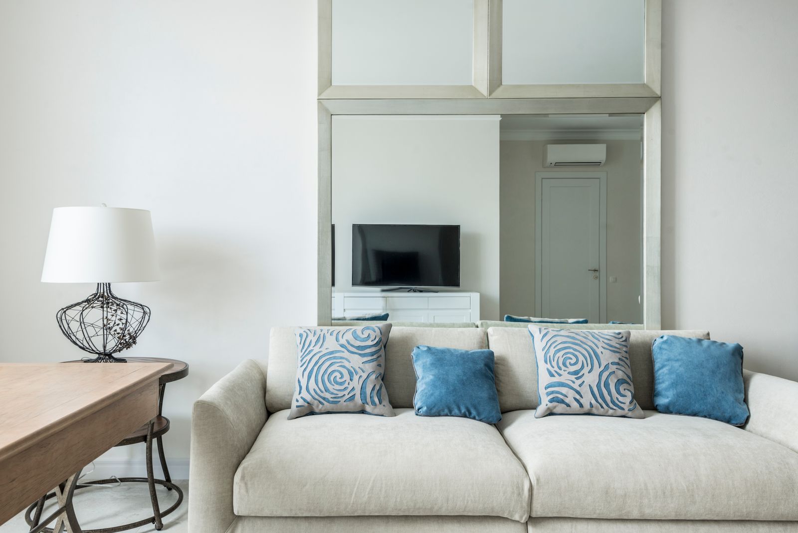 Beige sofa with blue cushions in a bright living room