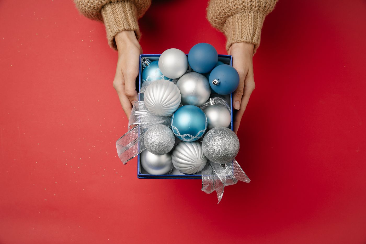 A box of blue and silver hanging ornaments held level