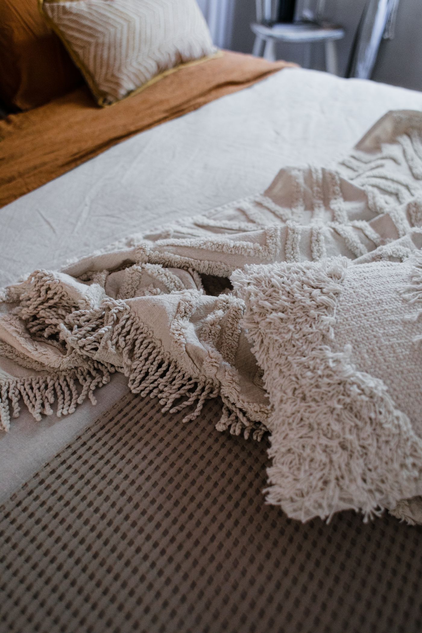 Fringed throw arranged on a bed