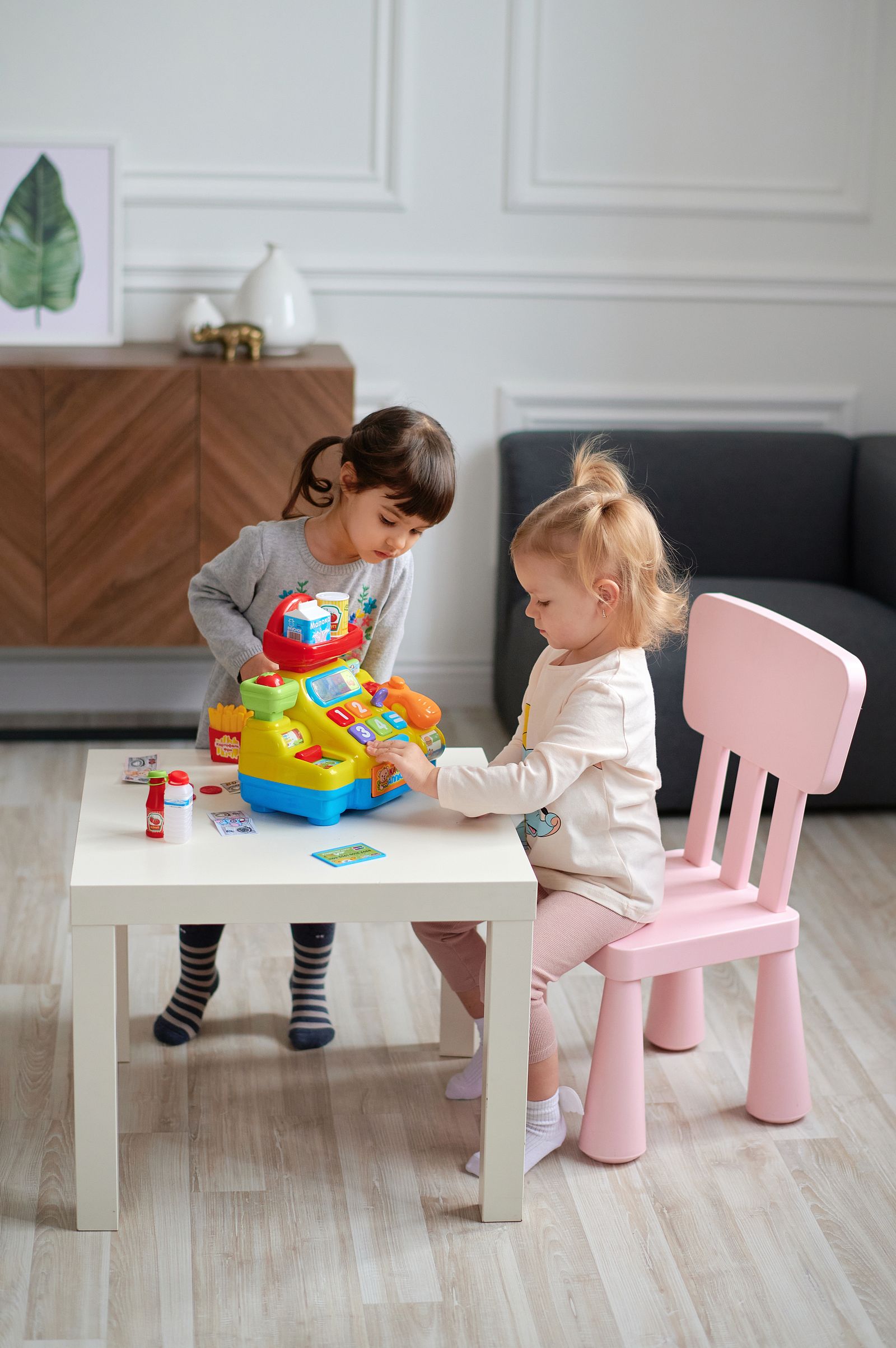 Two children playing with a toy at a low table
