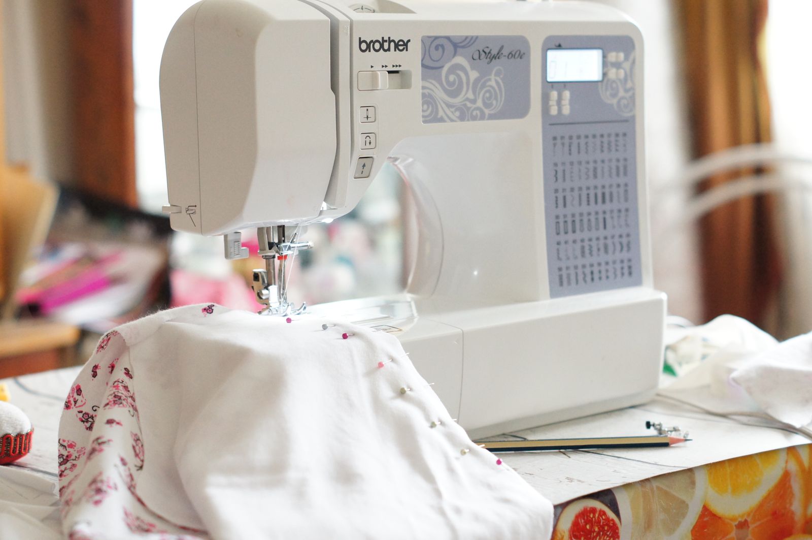 A sewing machine beside fabric on a table