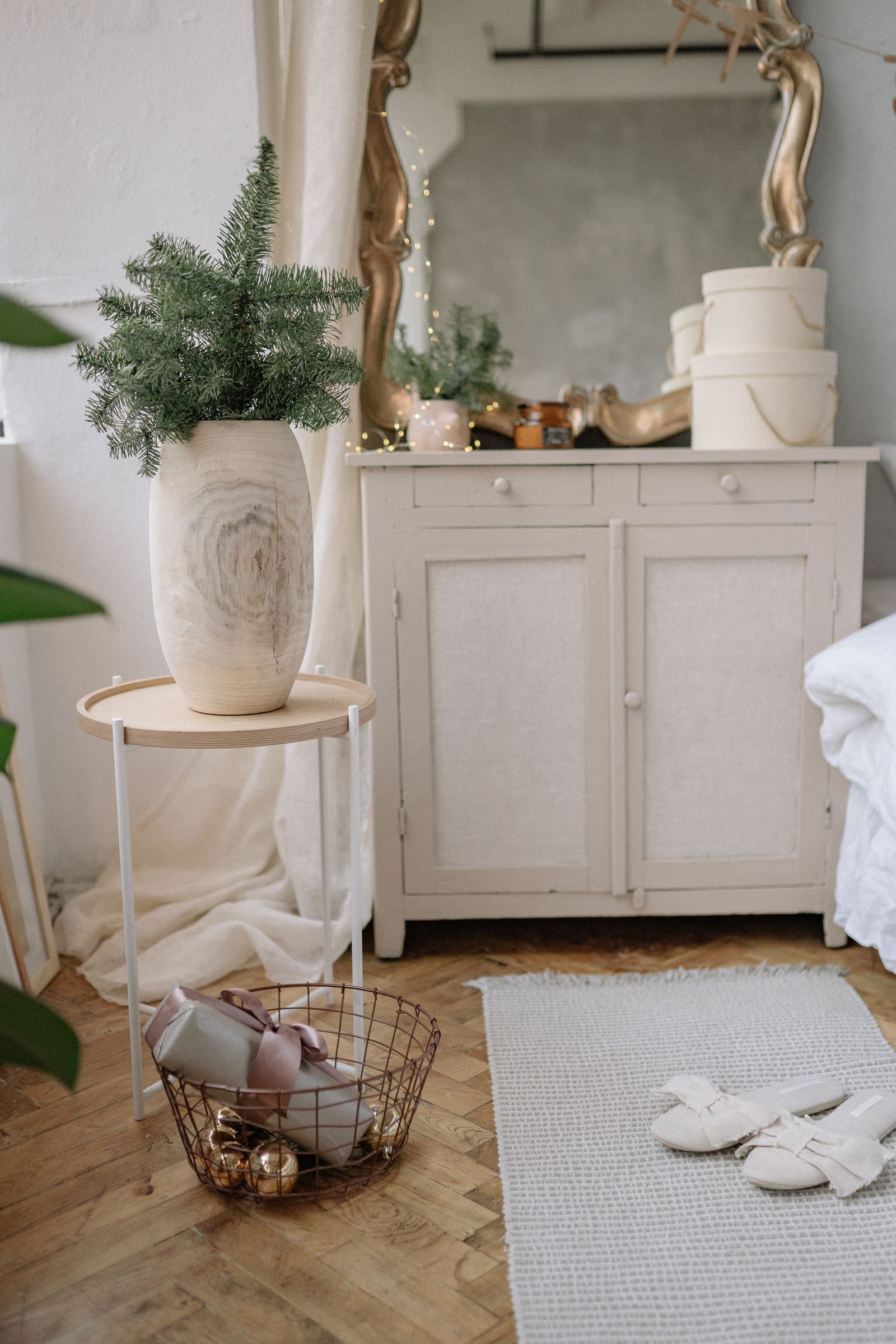 A pale dresser with mirror and objects on top