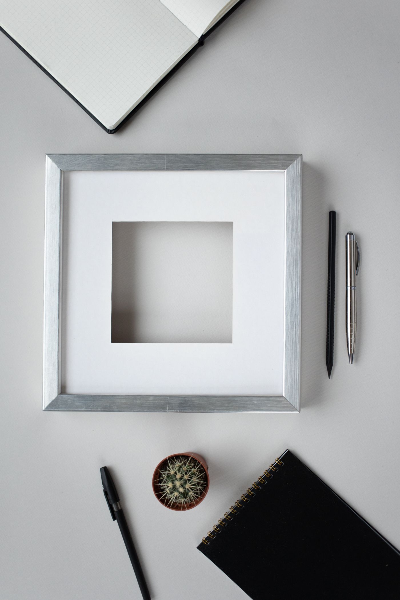Conventional square frame beside a notebook on a desk