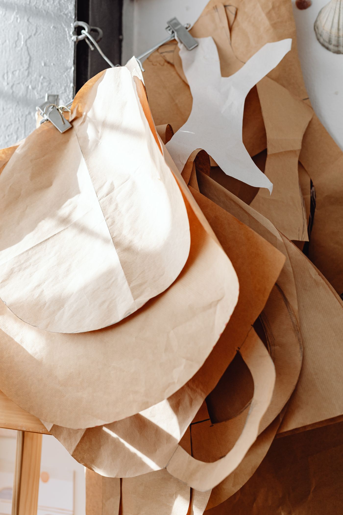 Paper sewing-pattern pieces hanging together in a work area
