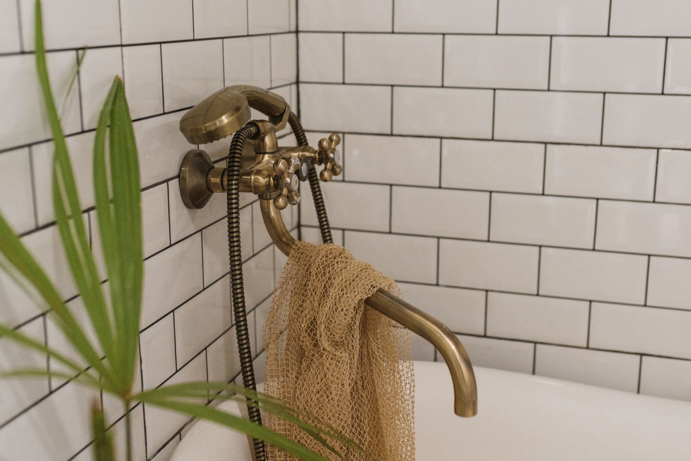 A metallic bath fitting beside a draped towel