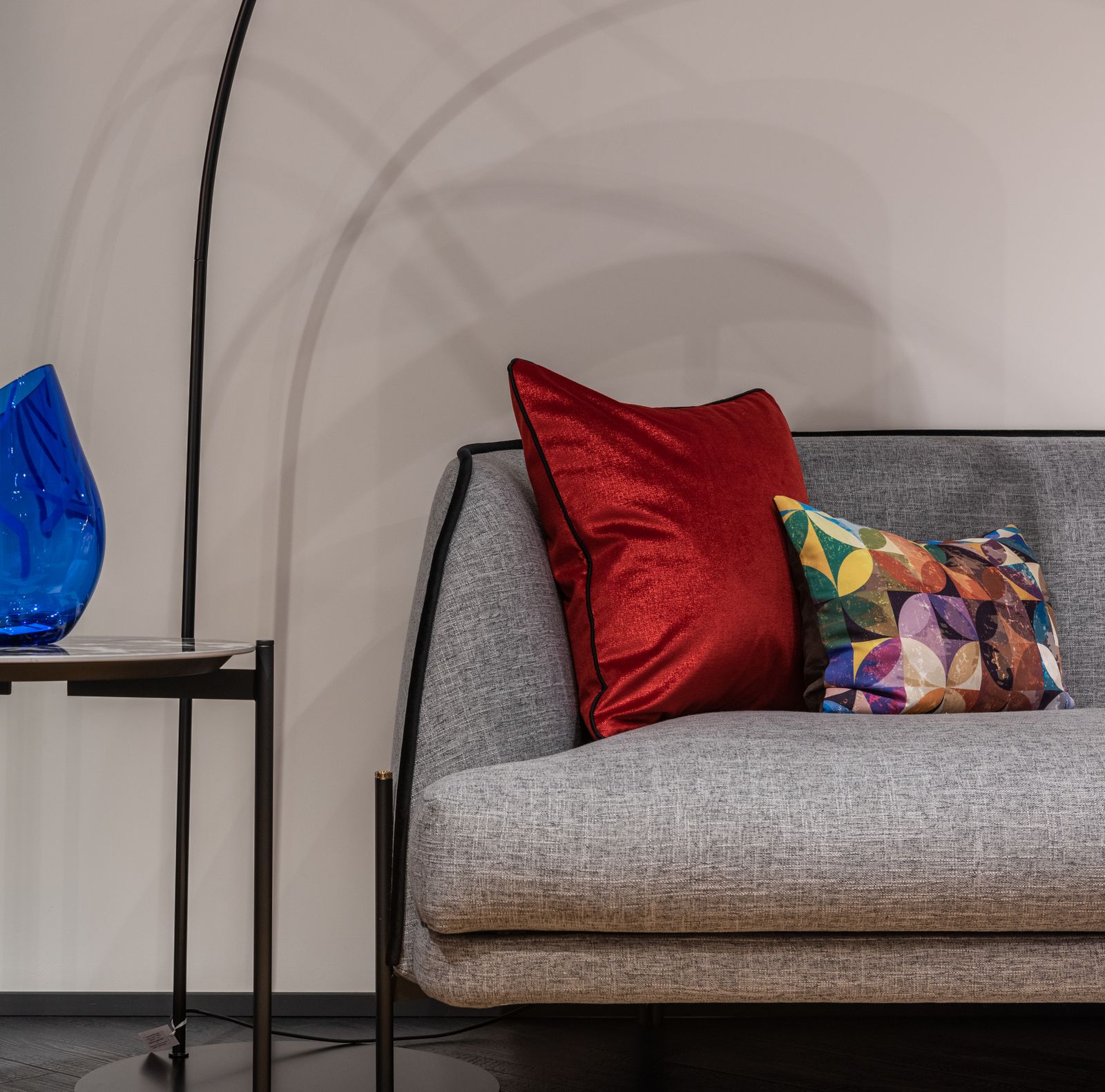 Red and patterned cushions on a gray sofa