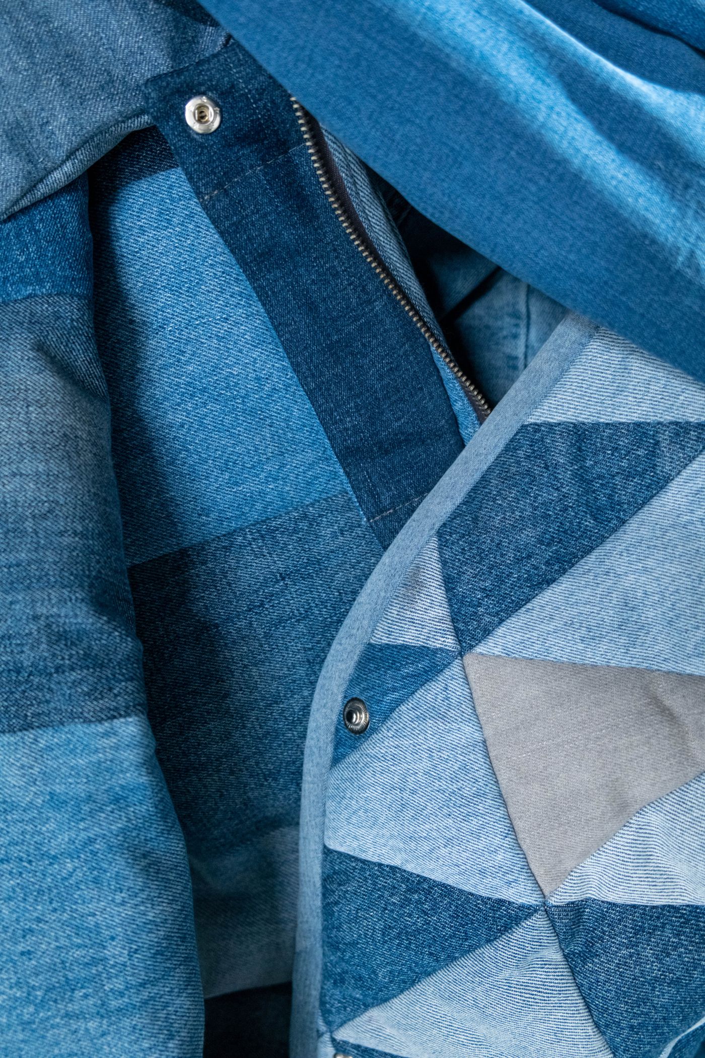 Denim garment beside a patchwork textile