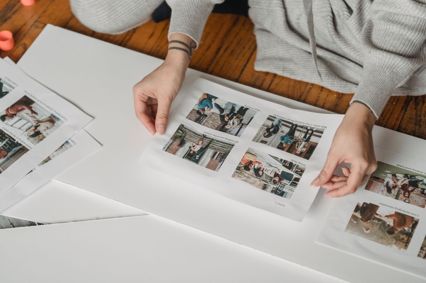Hands positioning photographs on a page; final assembly context