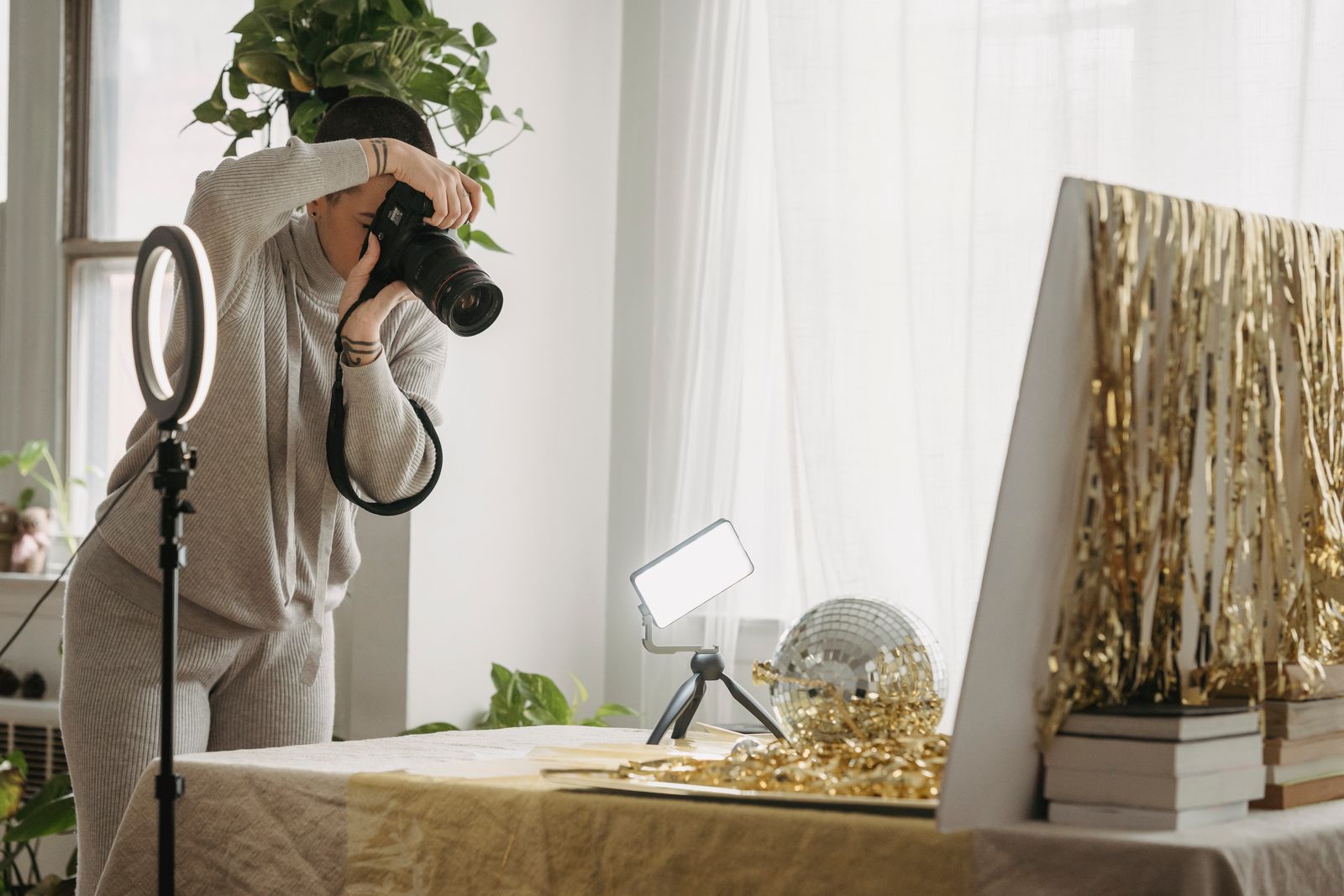 A photographer taking pictures of a reflective ball and gold decorations