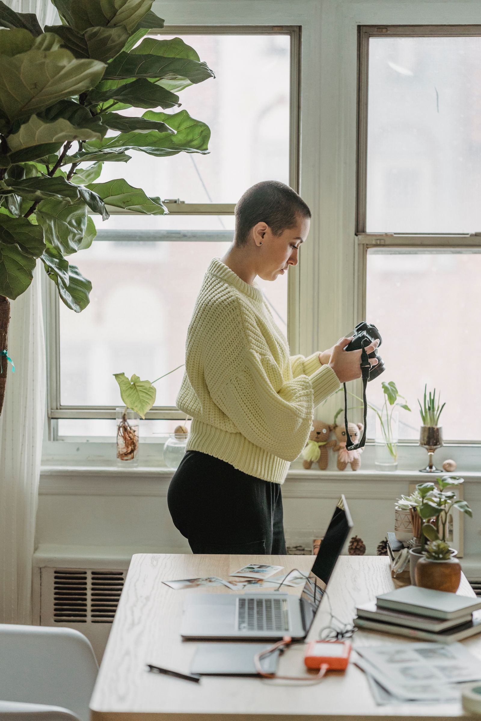 A photographer holding a camera beside equipment on a table