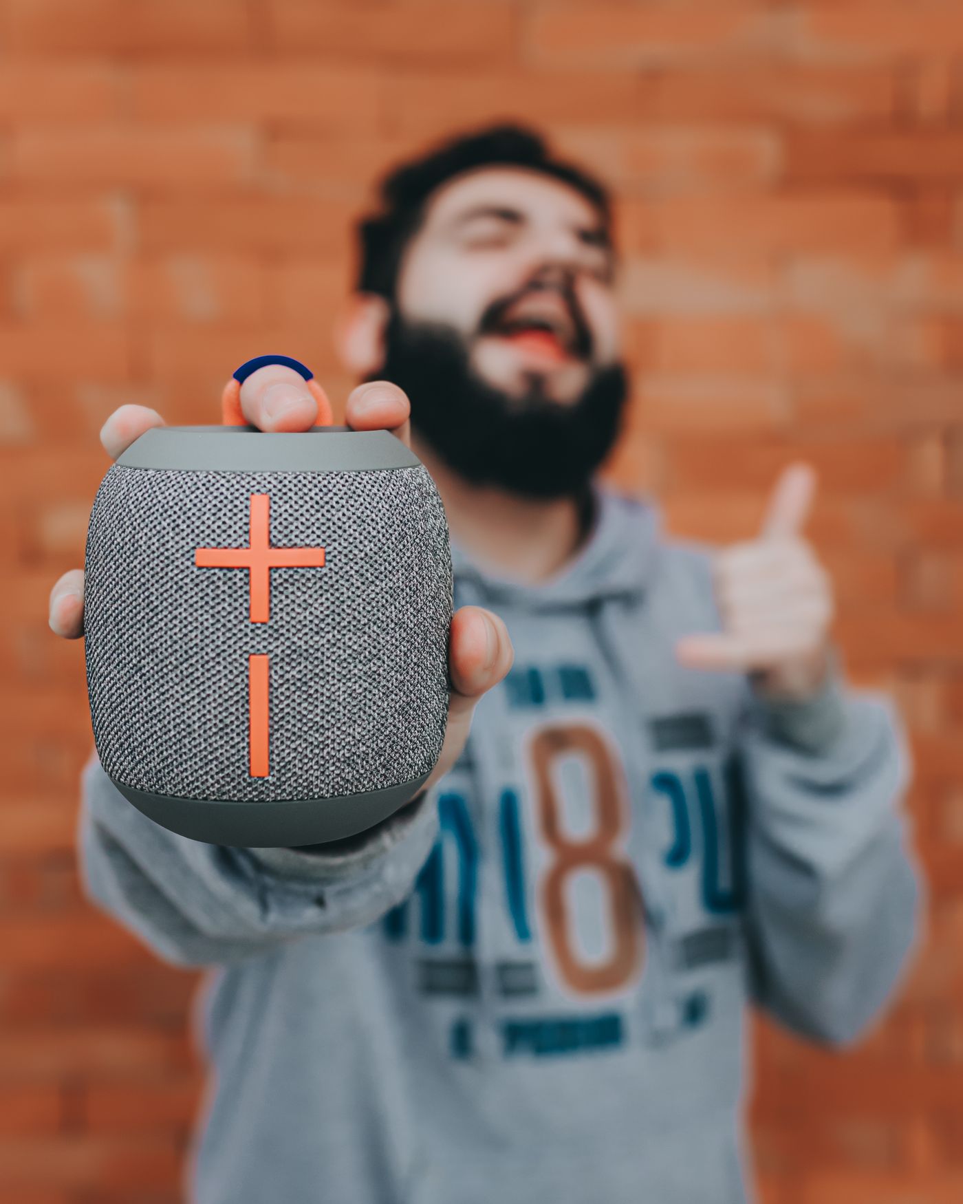 Person holding a small portable speaker
