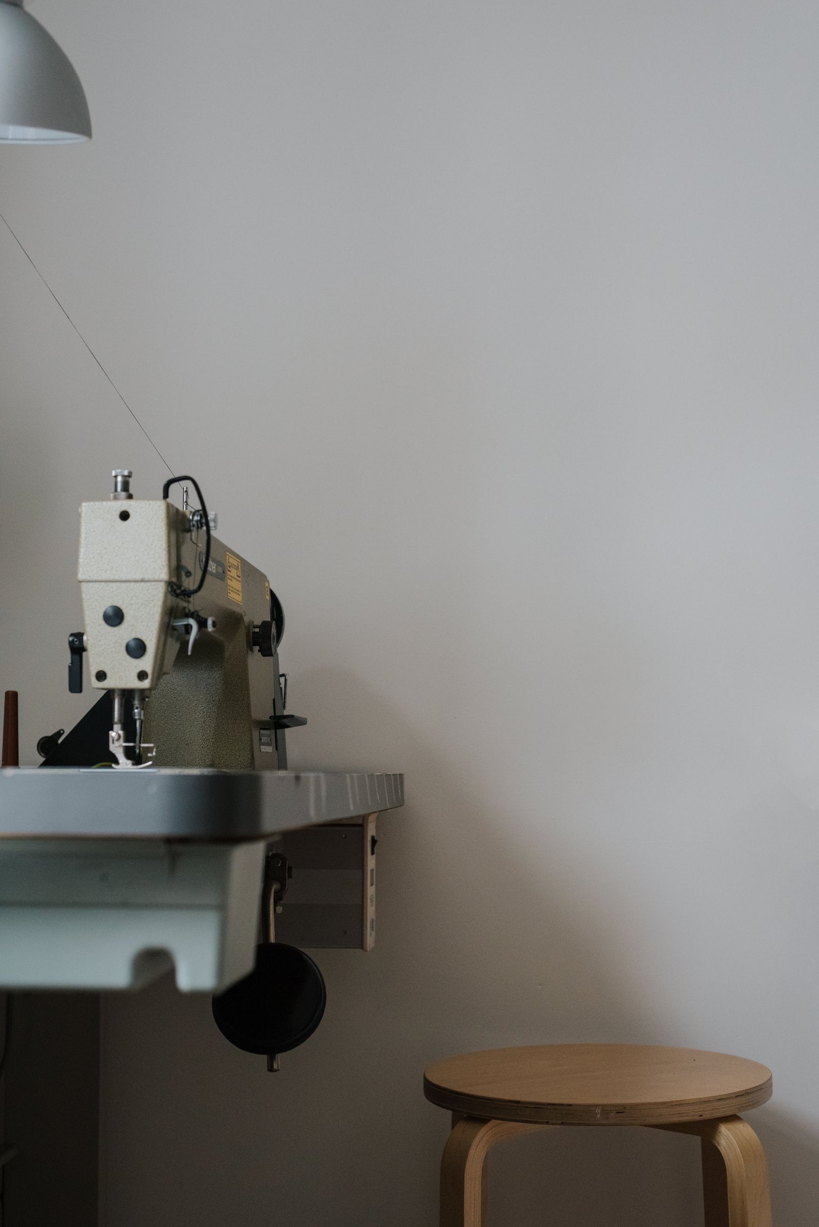 A sewing machine on a table beside a seat