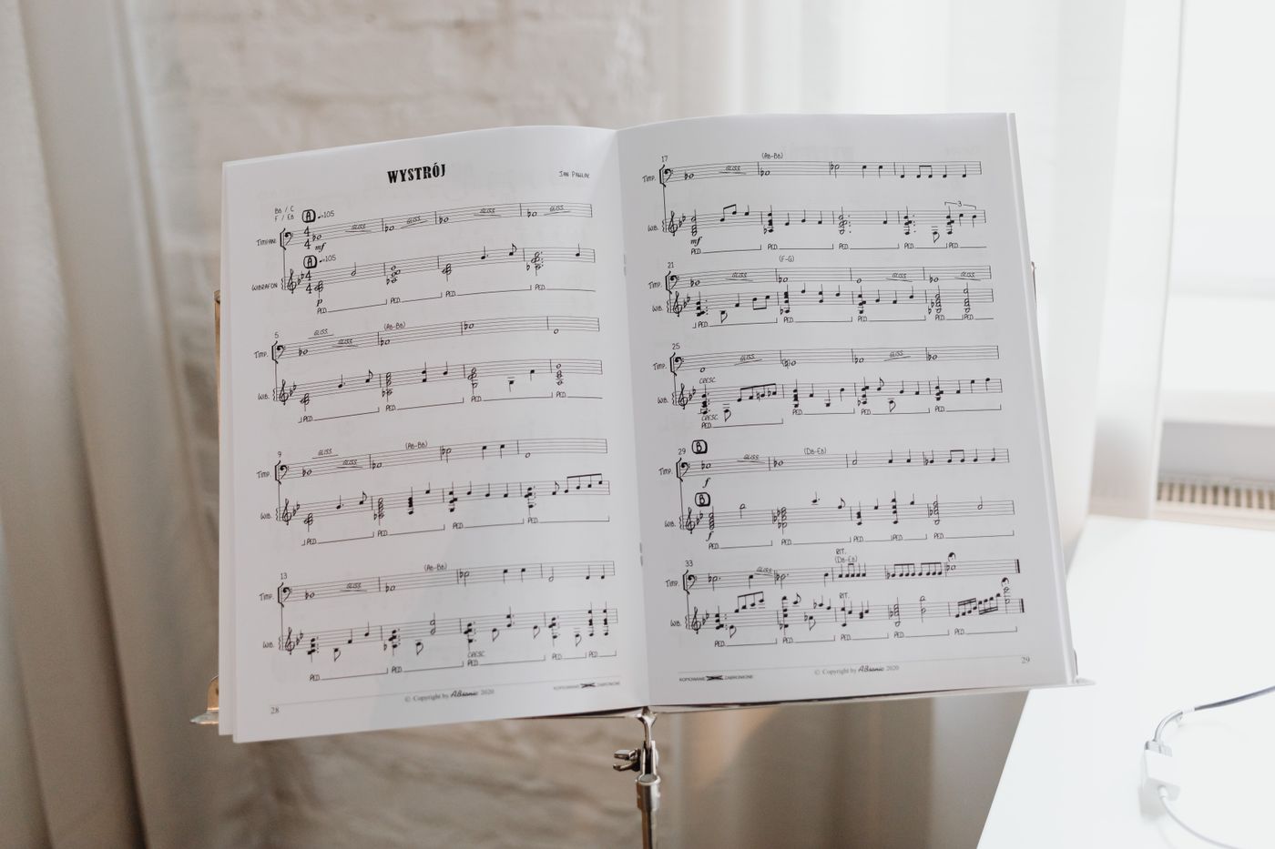 Printed music supported on a stand beside a keyboard