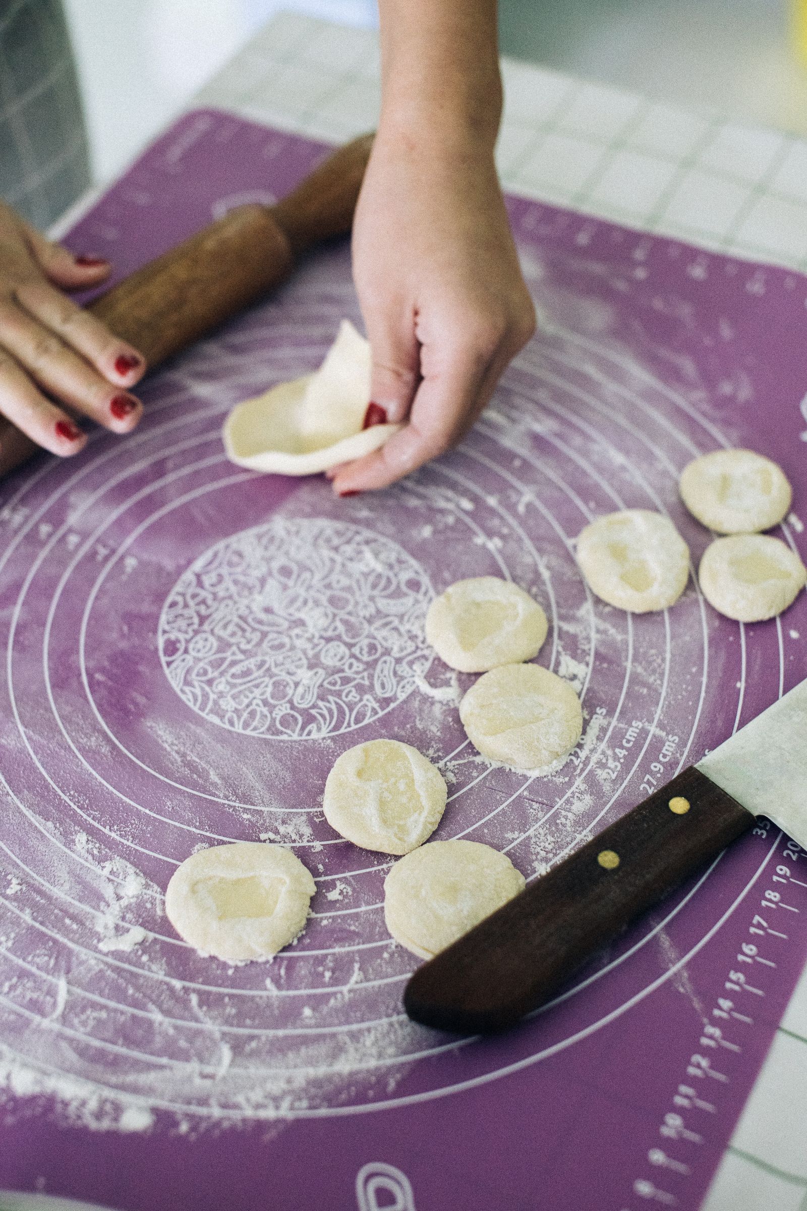 Dough shapes and baking tools on a purple pastry mat