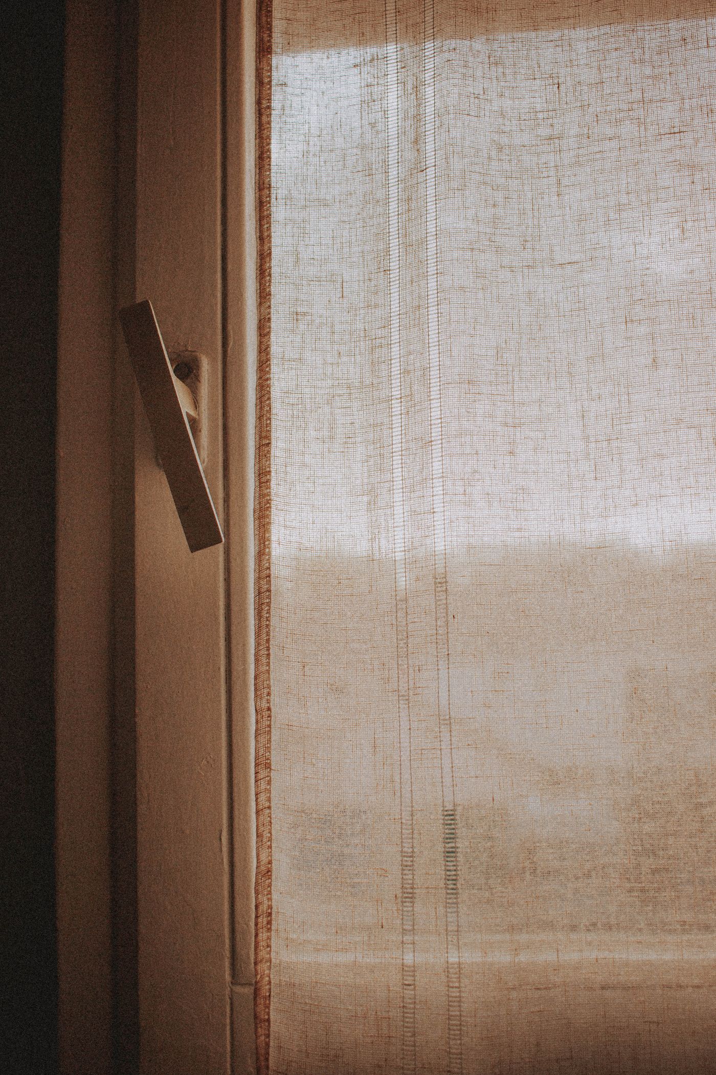 A light textile layer beside a window handle