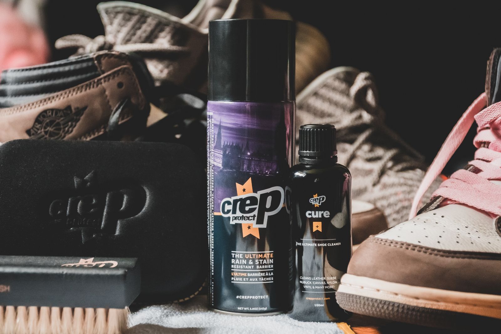 Shoe-care bottles beside dark and pale footwear