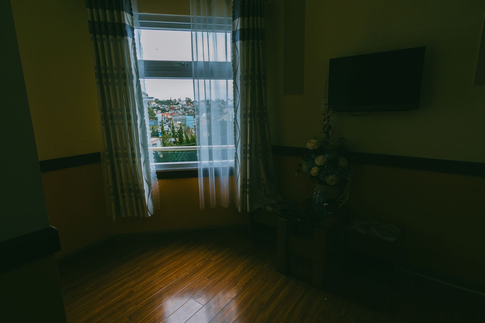 A lit room with a window overlooking a city