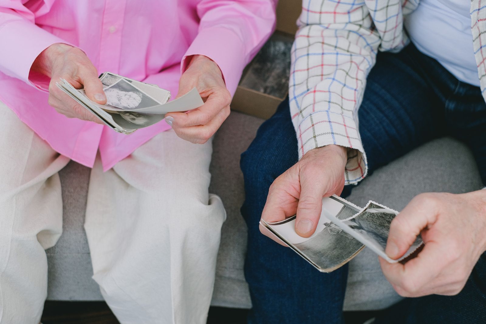 Two older people holding loose photographs together