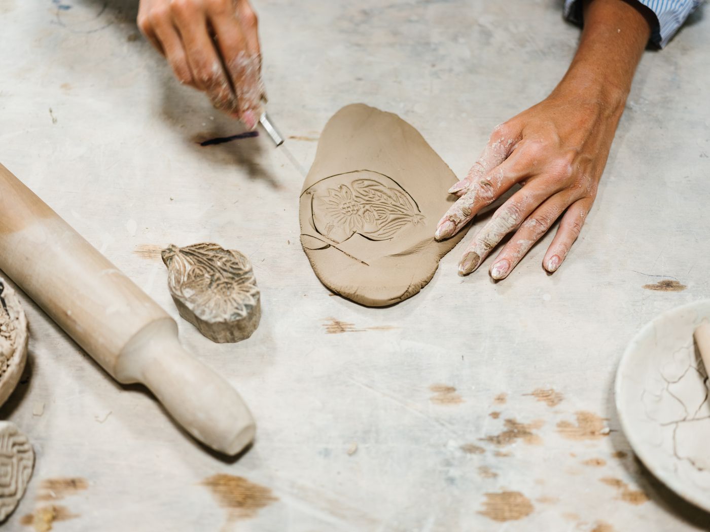 Leaf impression on rolled clay beside a rolling pin