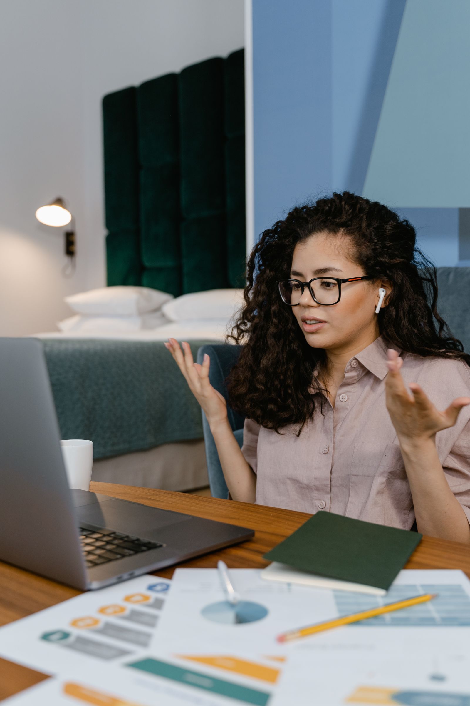 A person discussing artwork through a laptop in a shared room