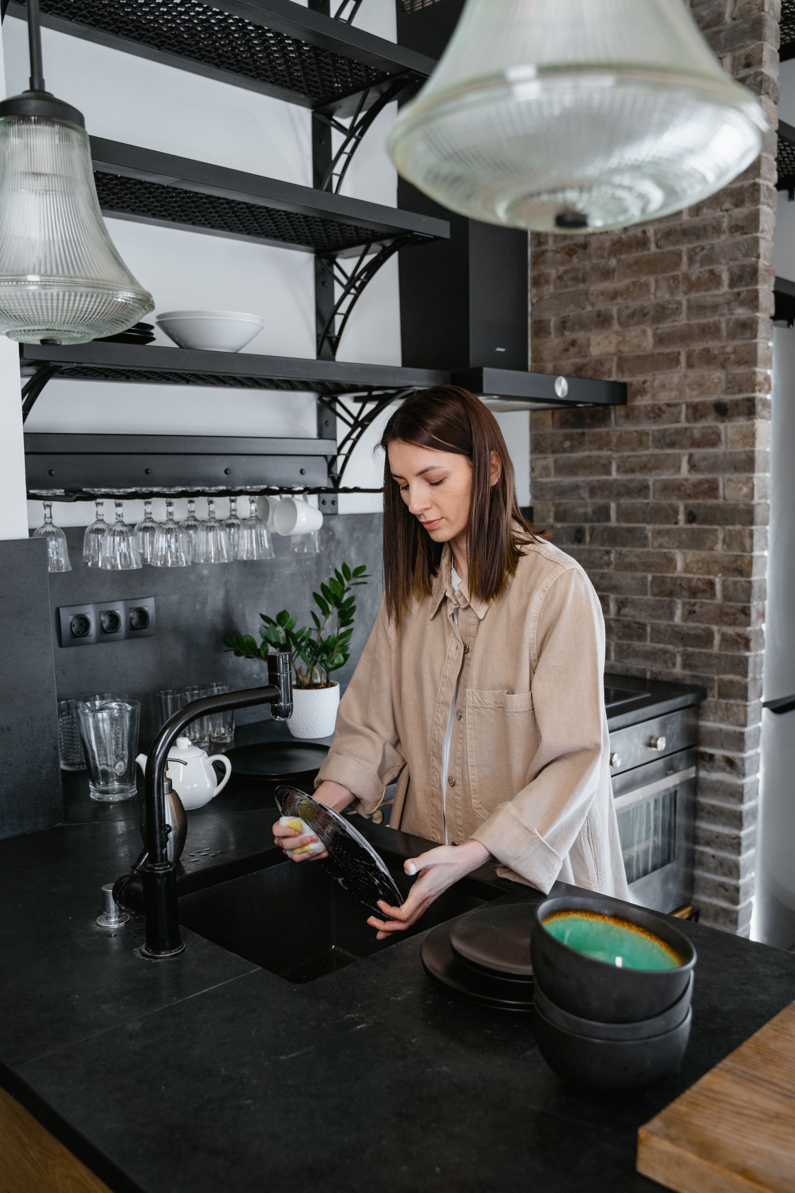 A person washing dishes at a kitchen sink