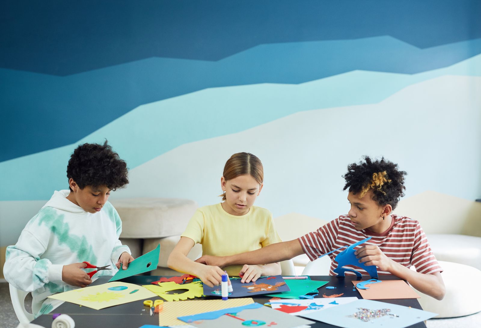 A child working with colorful paper at a craft table