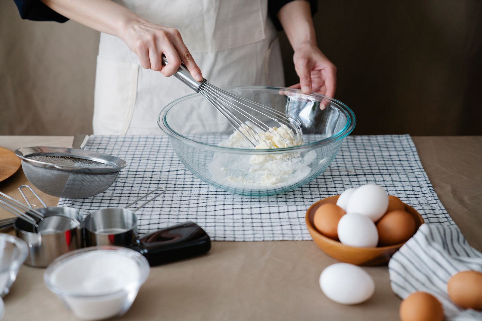 A person whisking ingredients in a glass bowl