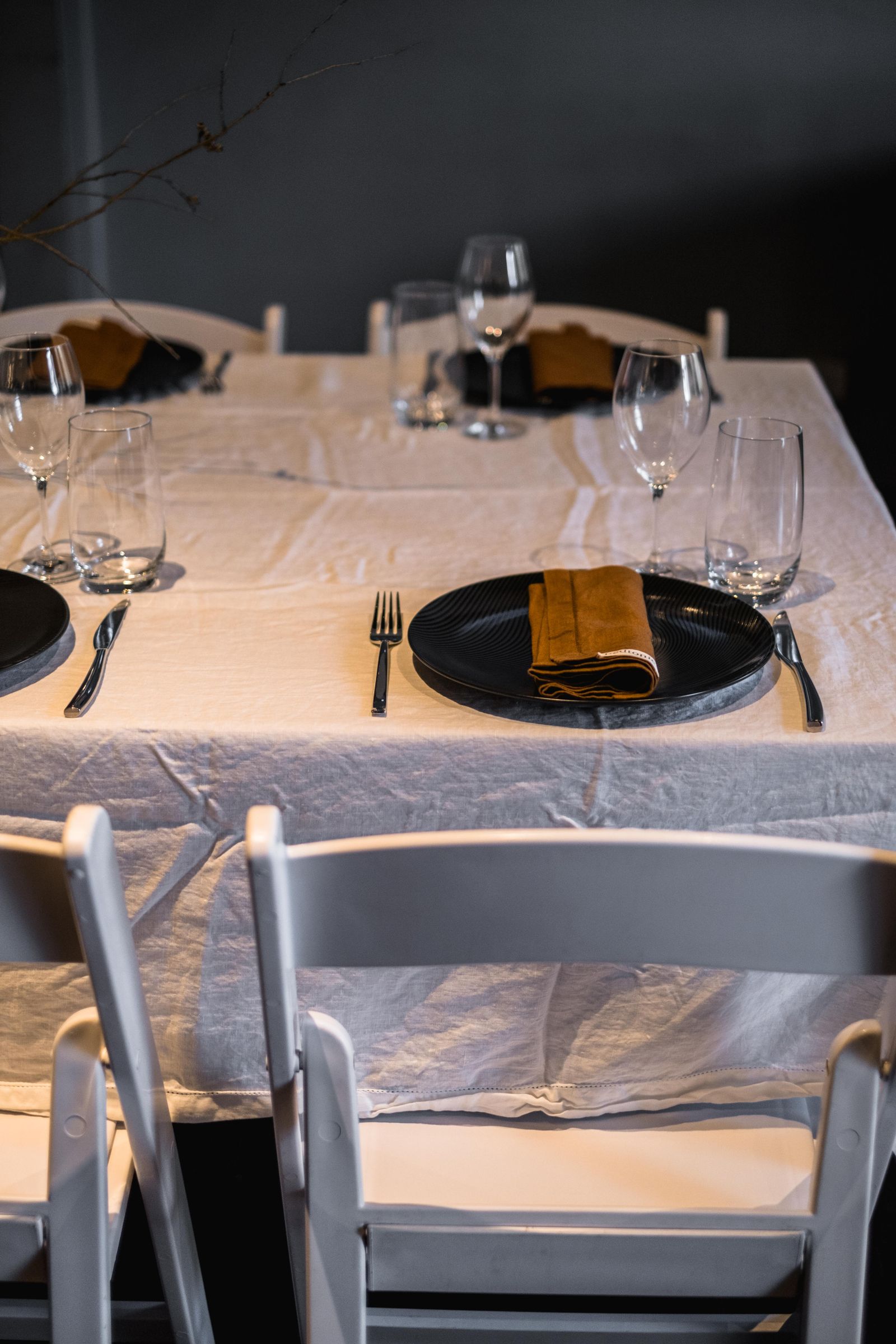 A restaurant place setting with a folded yellow napkin