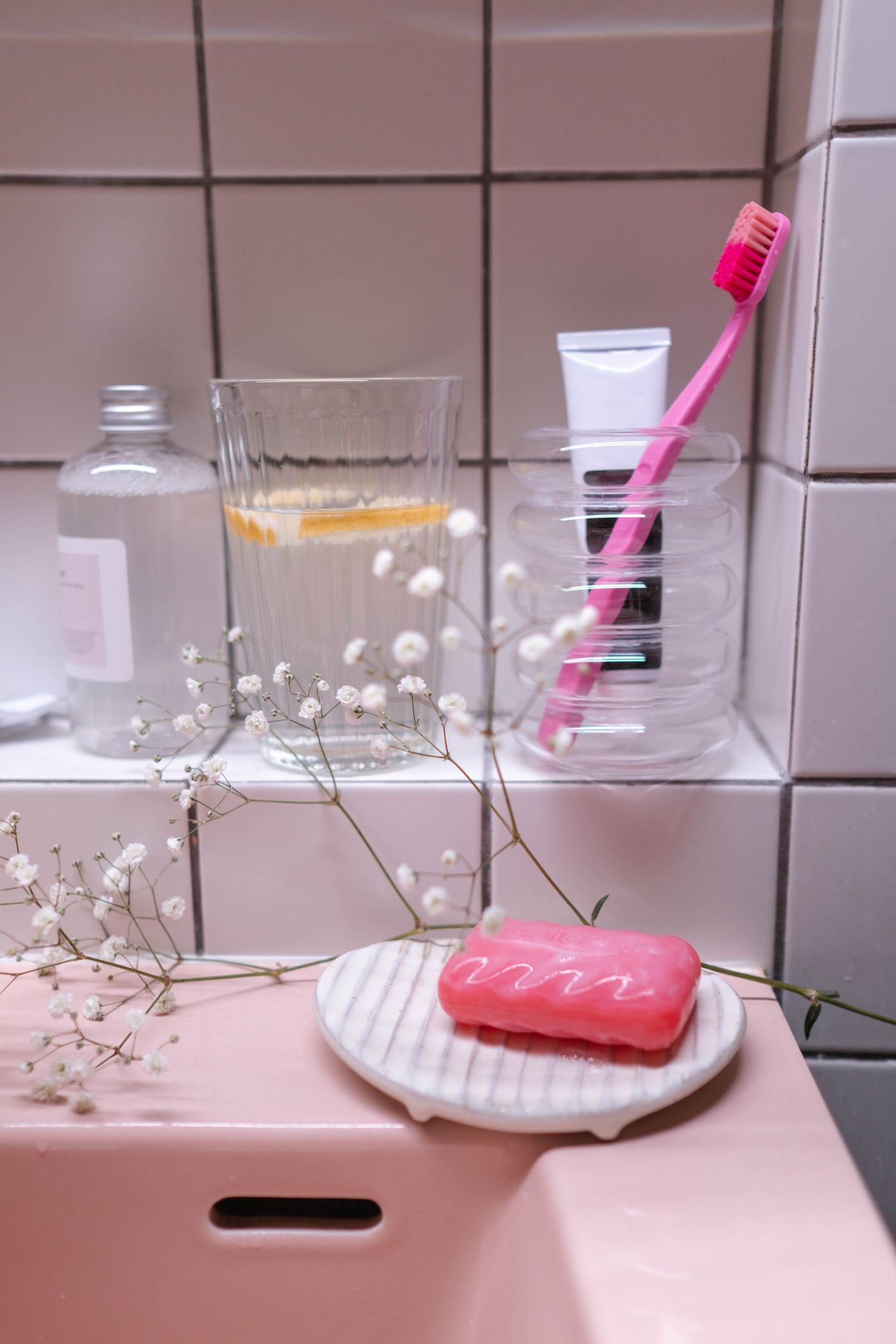 Separate toothbrush cup and toothpaste on a bathroom shelf
