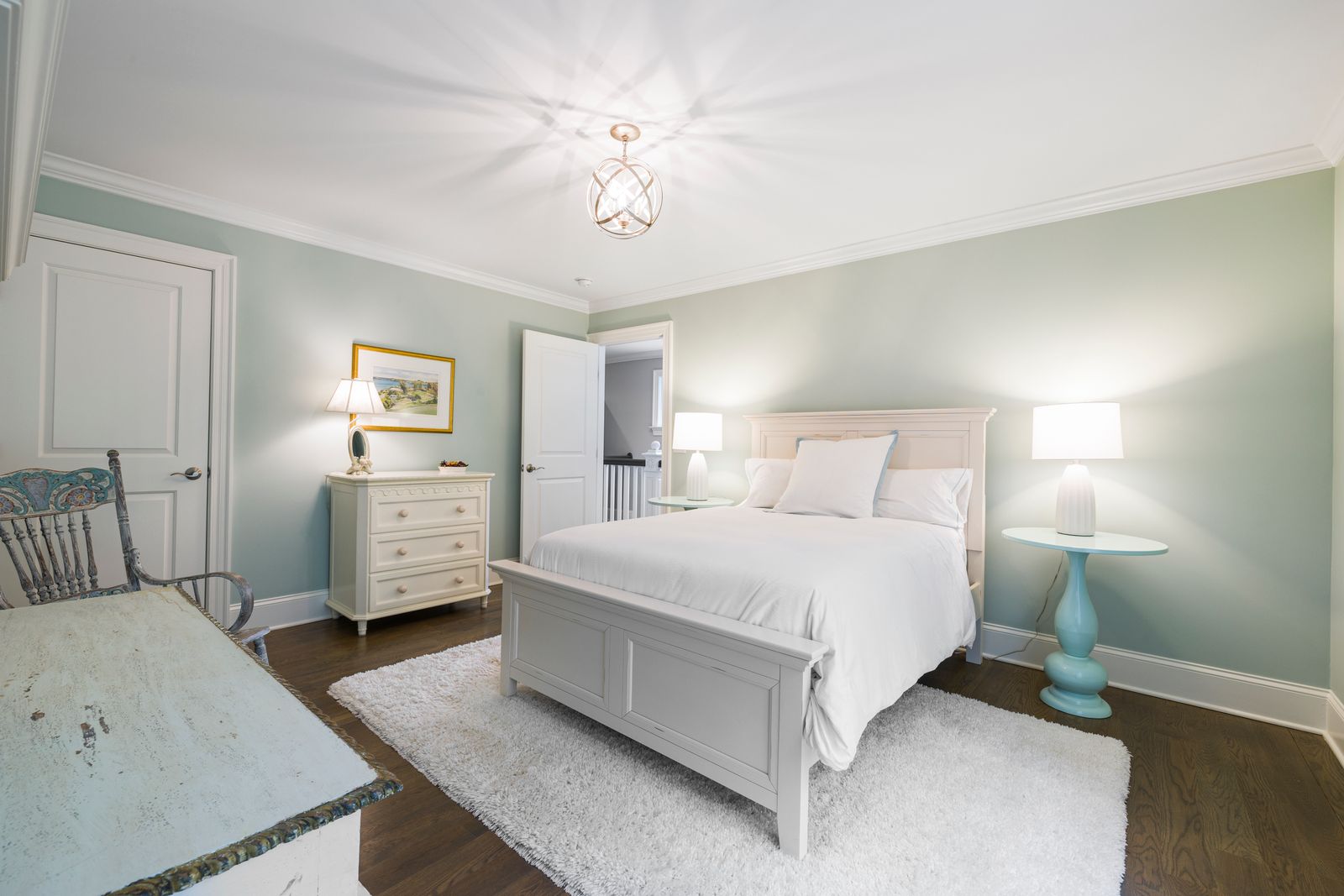 A bedroom with a bed, storage furniture, and doorway