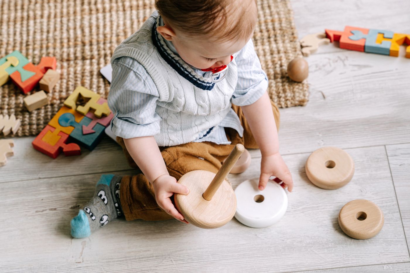 Child exploring a wooden stacking toy