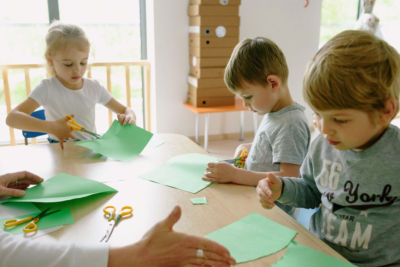 Young children working with paper and scissors