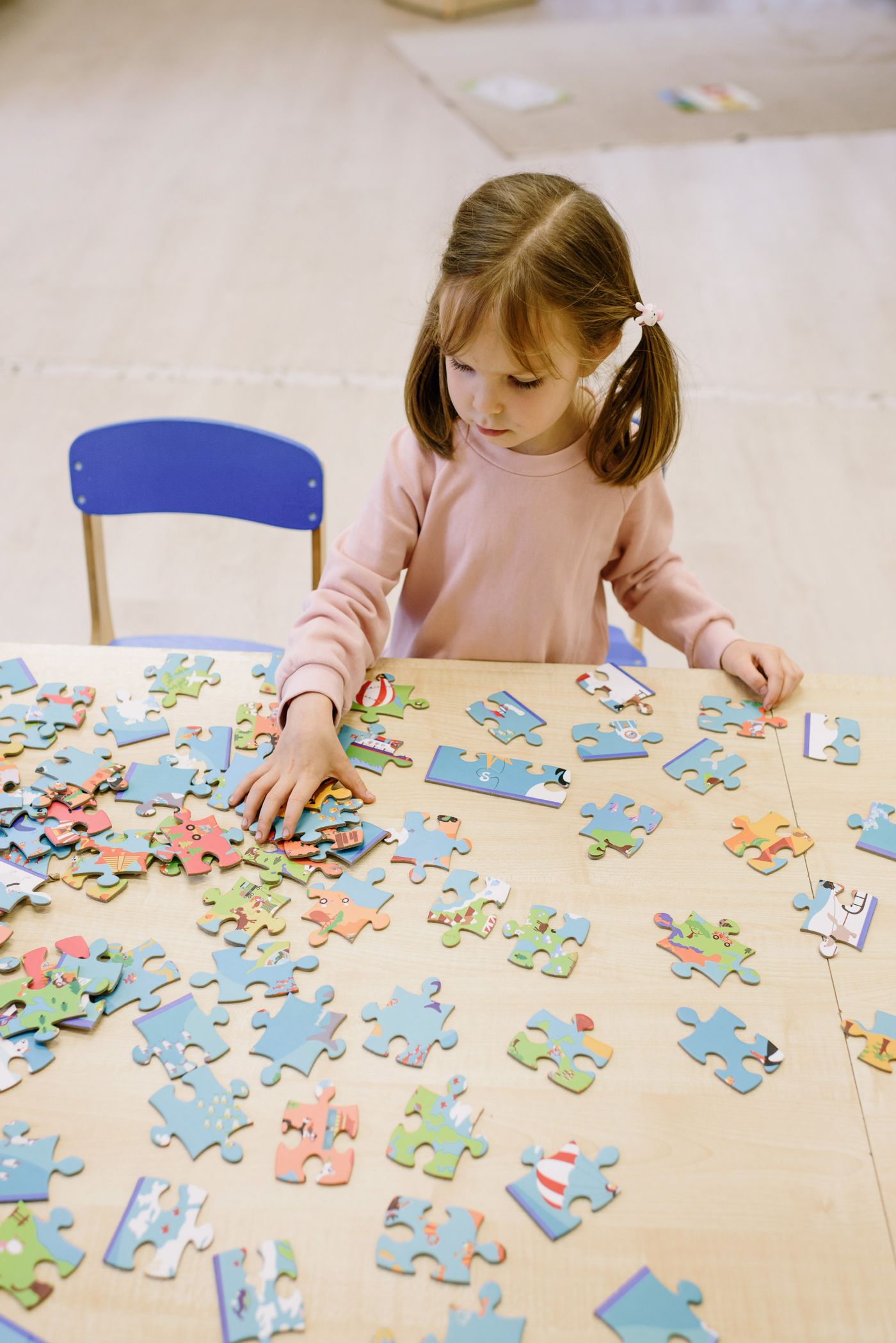 A child inspecting pieces laid out on a table