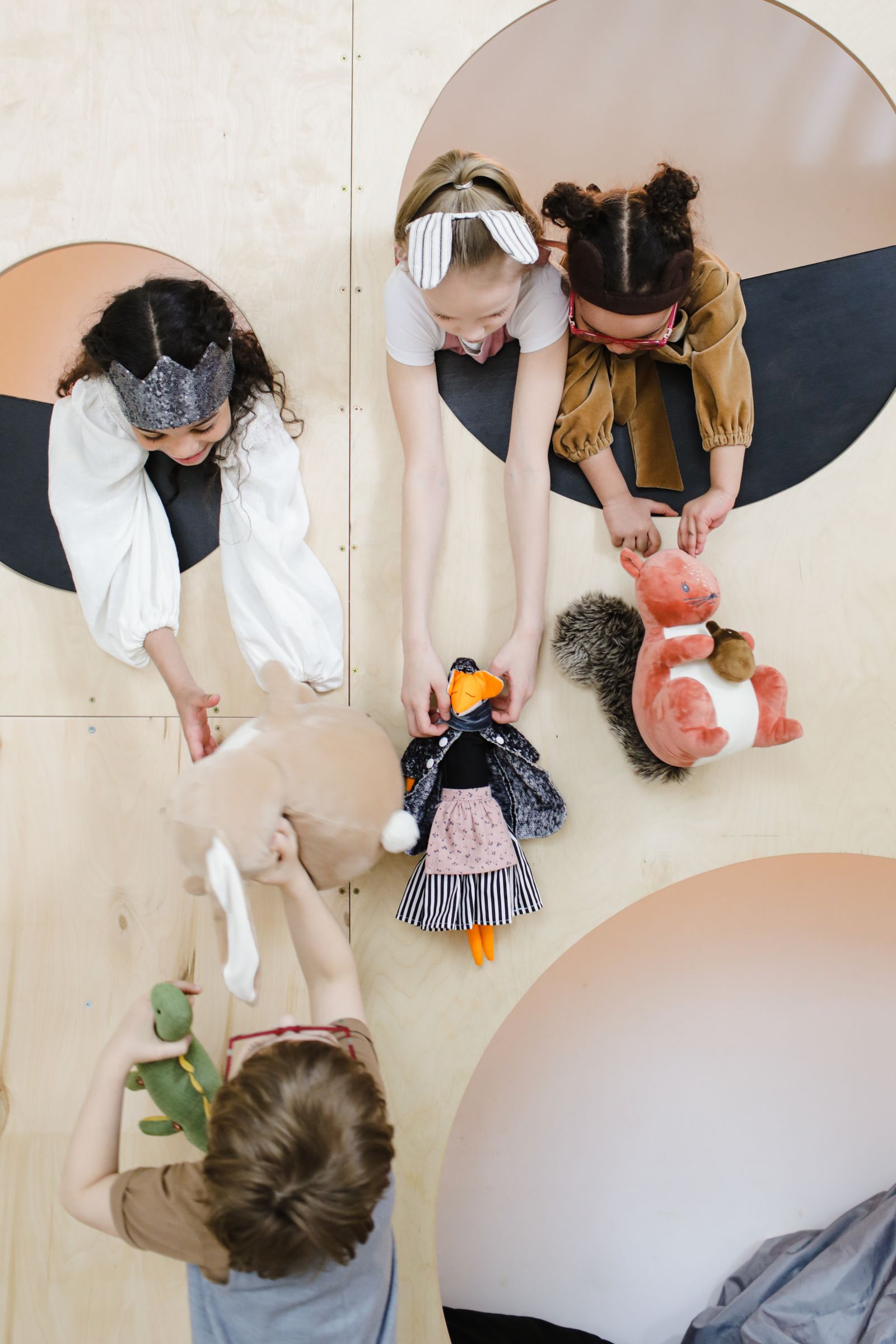 Children handling toys together on a play surface