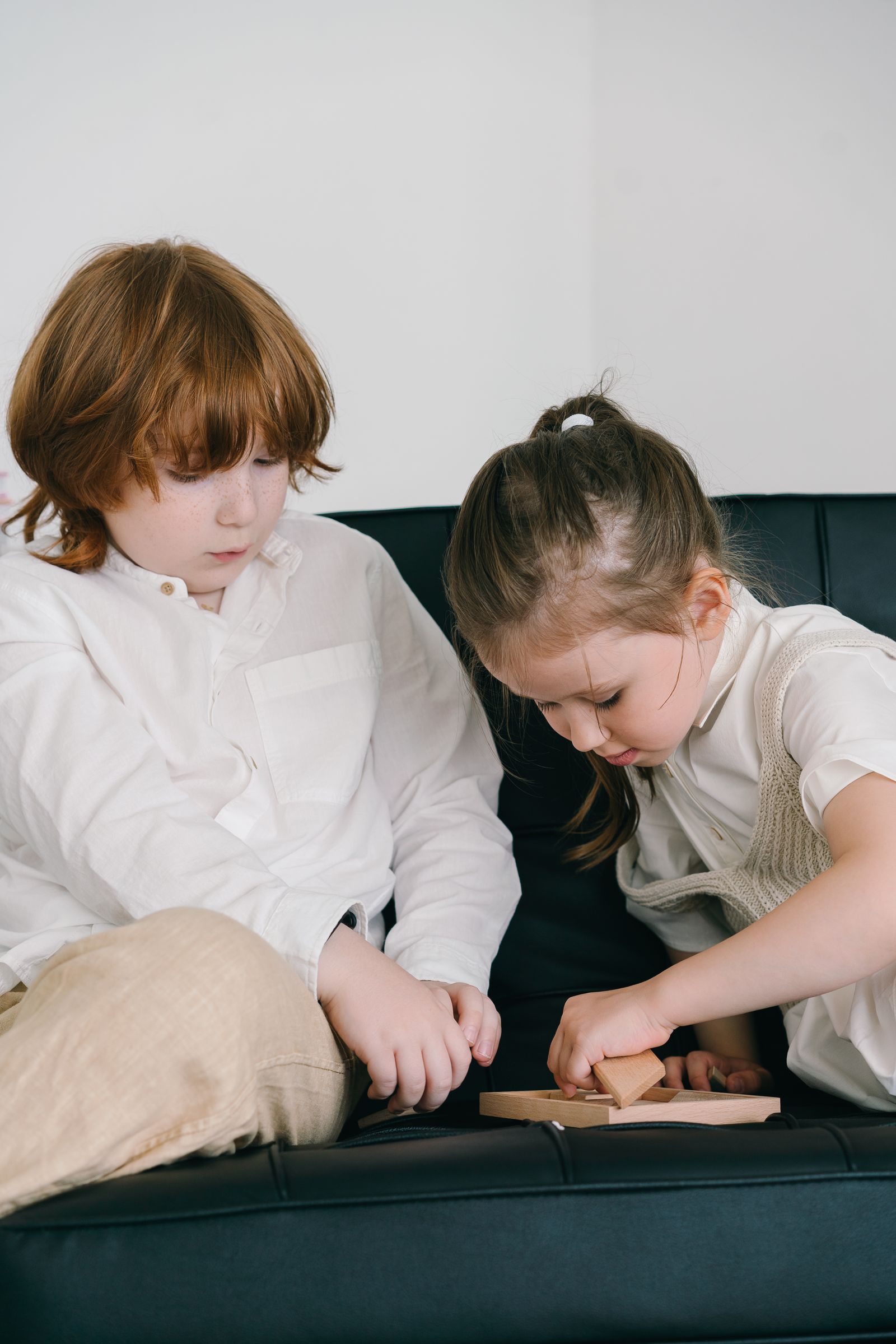 Two children concentrating on a game indoors