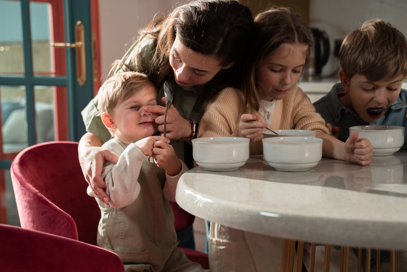 An adult beside children eating at a round table