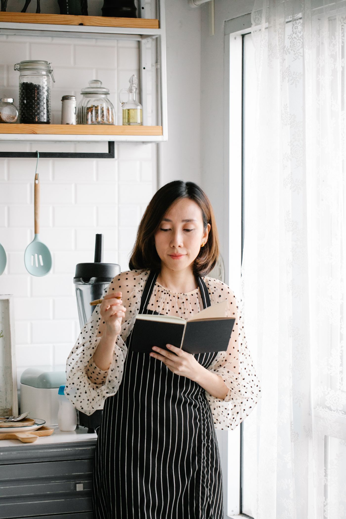 A person holding a notebook in a kitchen