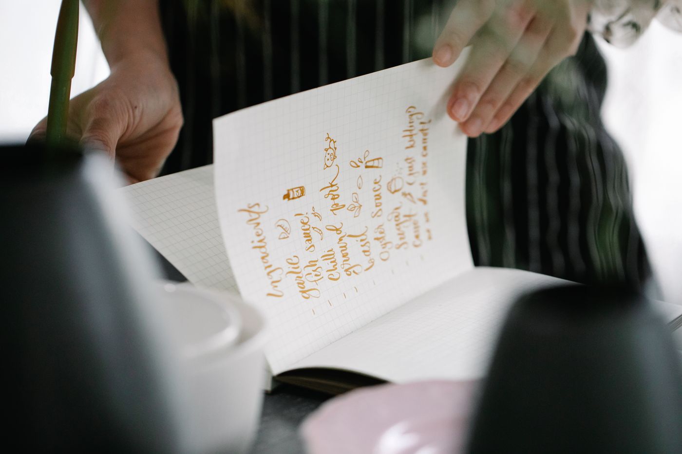 A handwritten ingredient page being held open