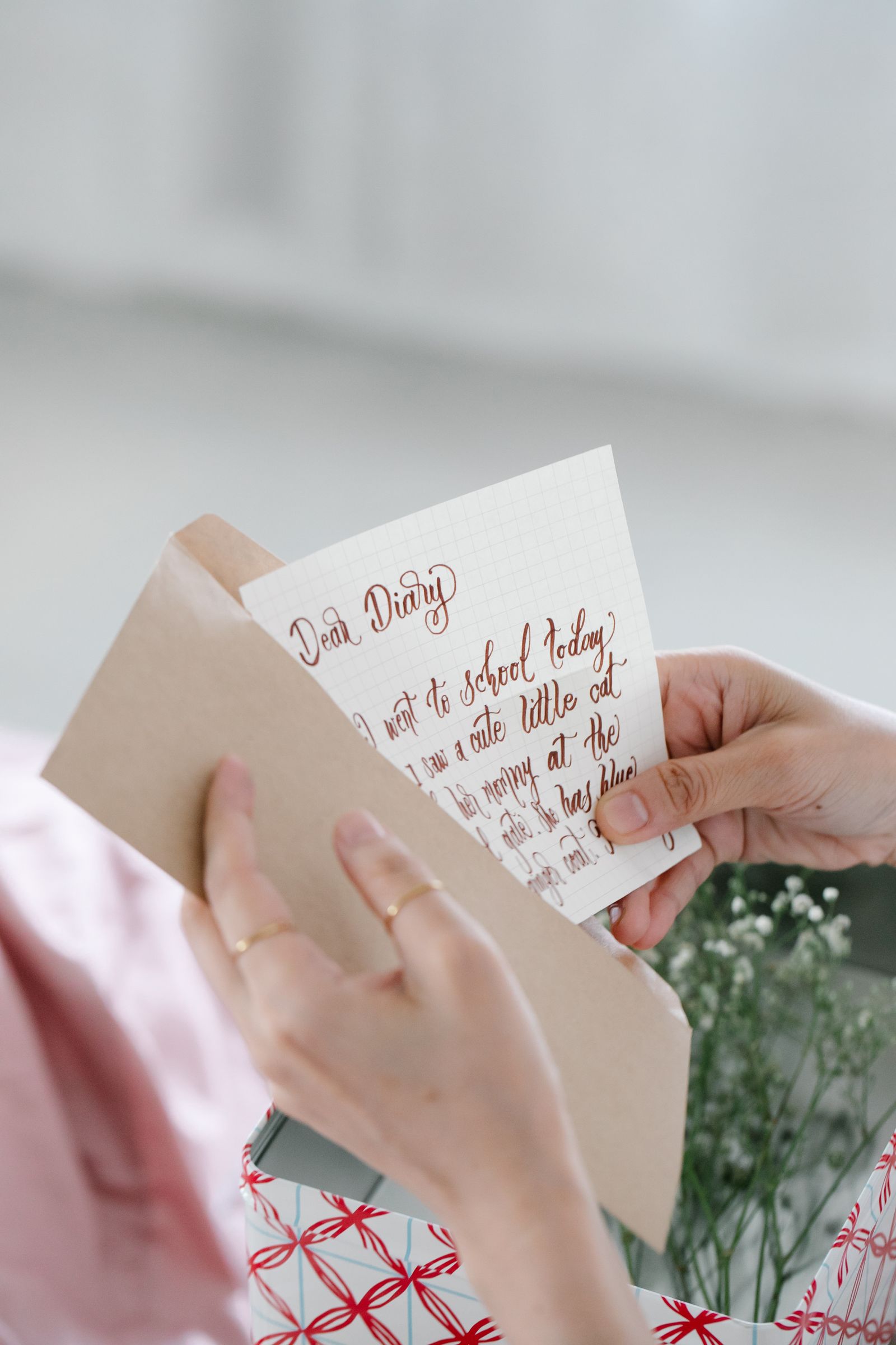 Hands removing a handwritten sheet from an envelope