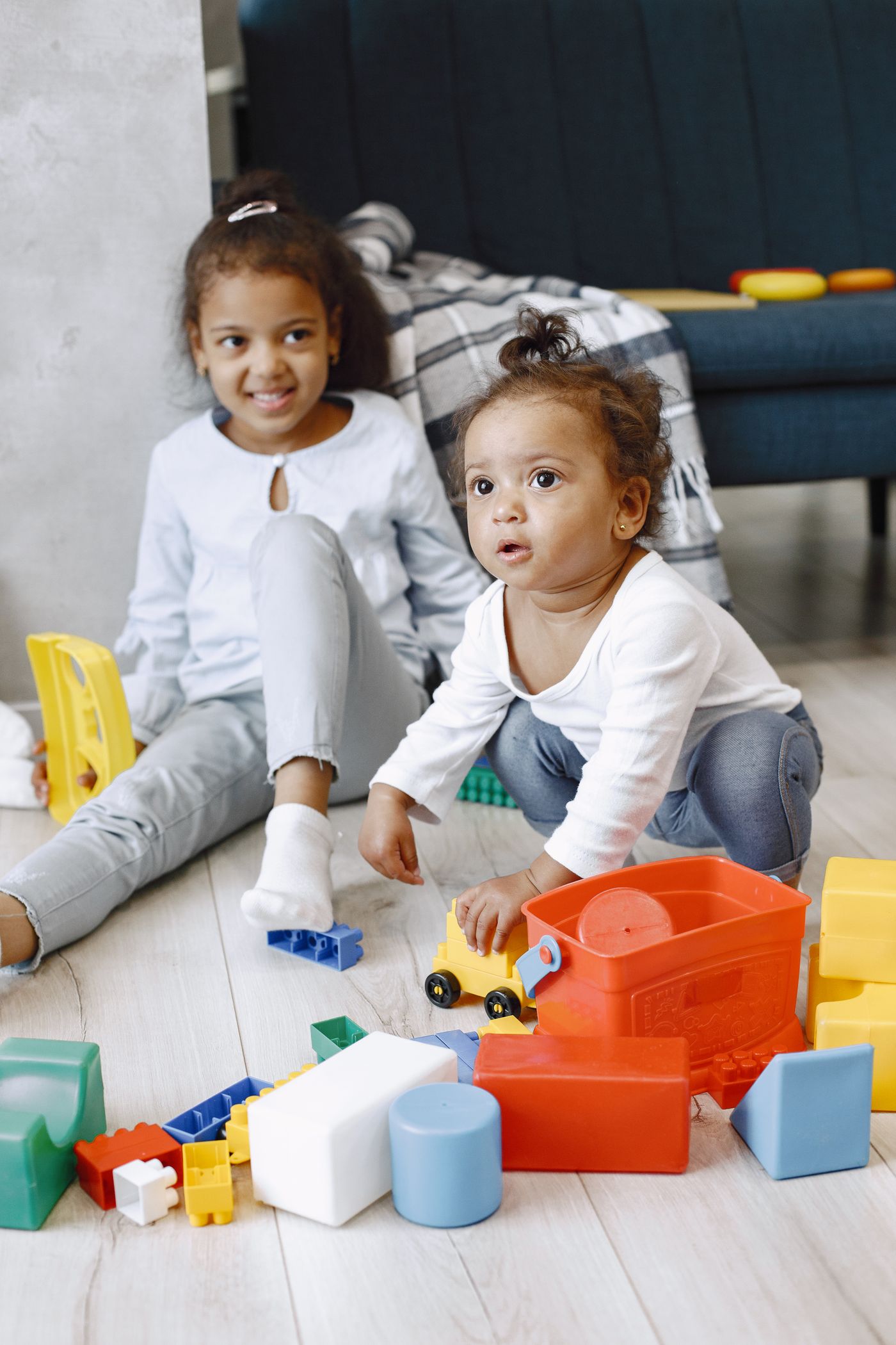 Two children playing with blocks on a floor
