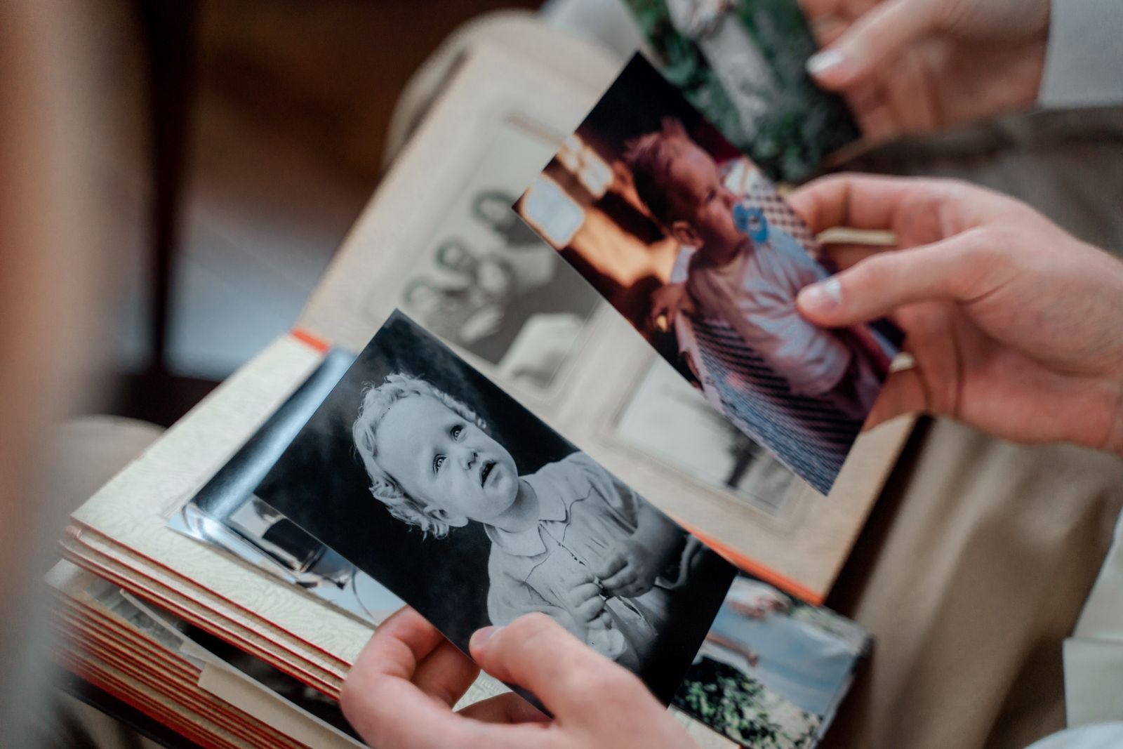 Hands turning an album page containing family photographs