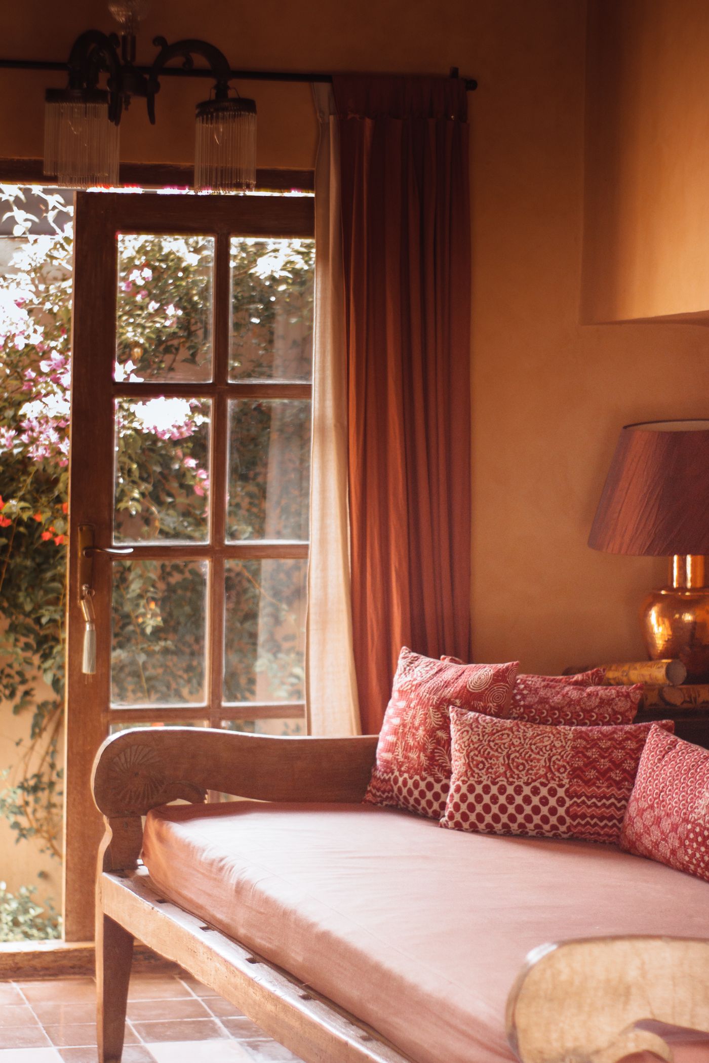 Wooden daybed beneath a bright window