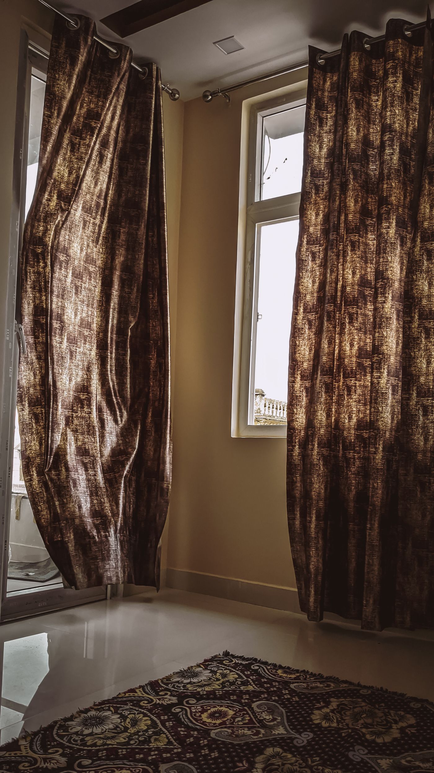 Patterned curtain panels opened beside a room window