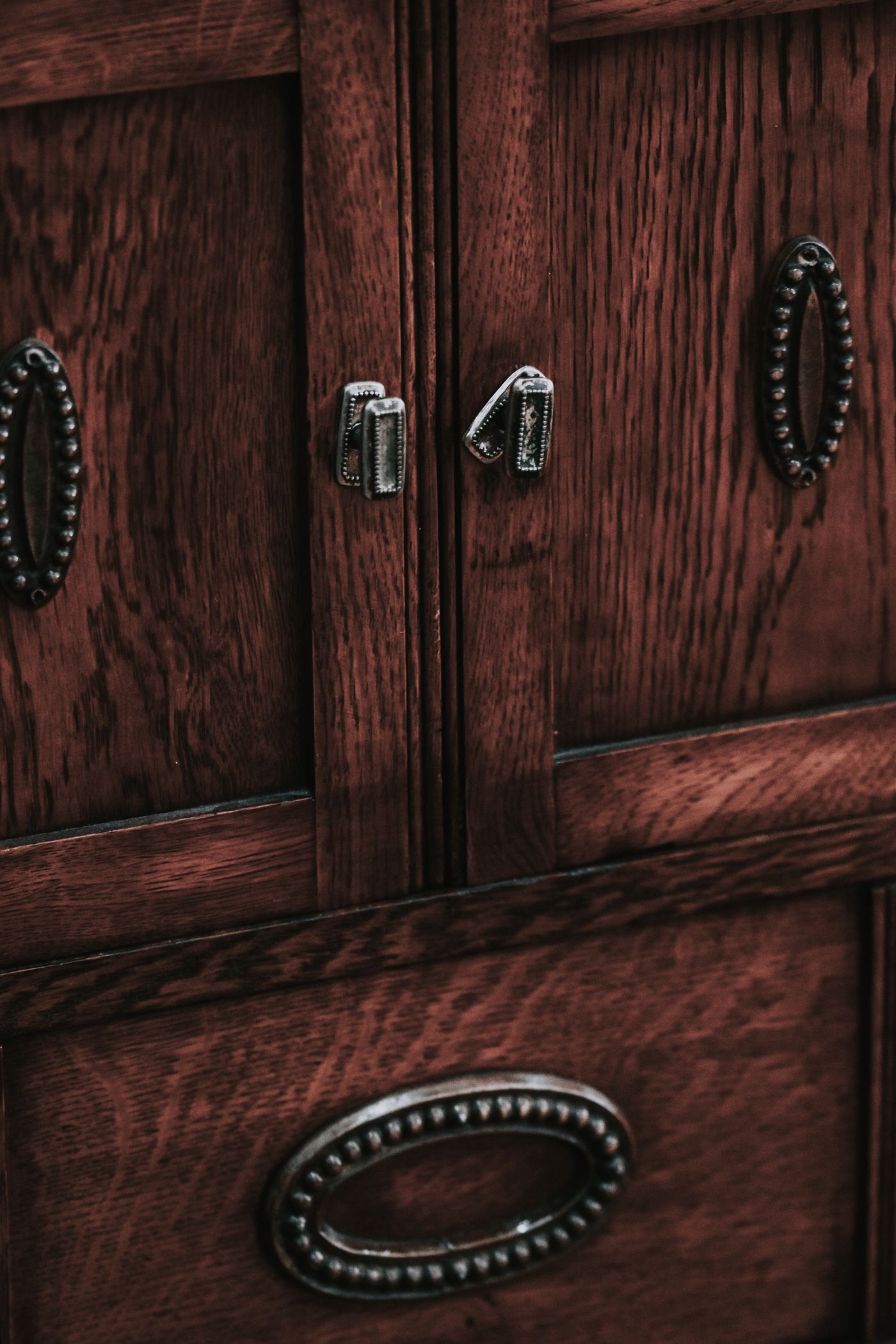 Dark wood cabinet showing different metal pulls