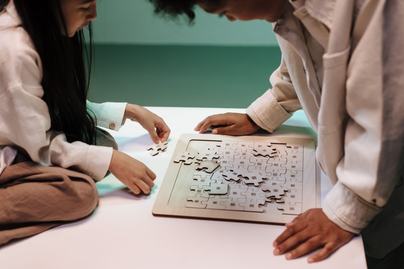 Two children working together on a jigsaw puzzle